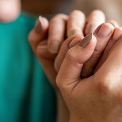 carer holding elderly womans hand
